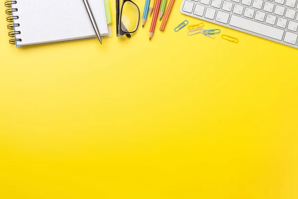 Escritório fundo amarelo com suprimentos e computador — Fotografia de Stock