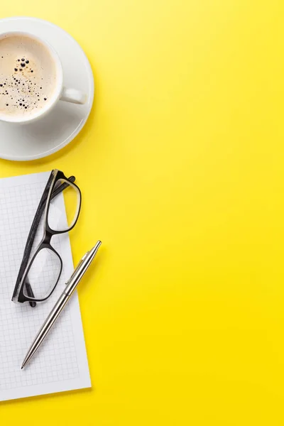 Büro gelb Hintergrund mit Kaffee und Vorräten — Stockfoto