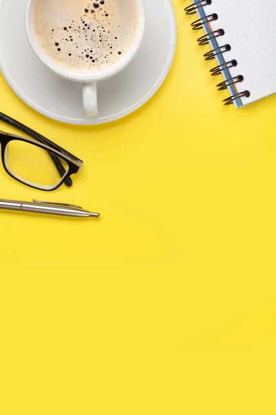 Bureau jaune lieu de travail avec tasse à café et fournitures — Photo