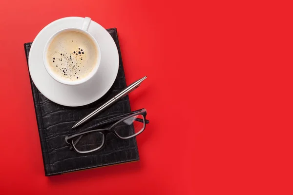 Escritório local de trabalho vermelho com xícara de café, suprimentos — Fotografia de Stock