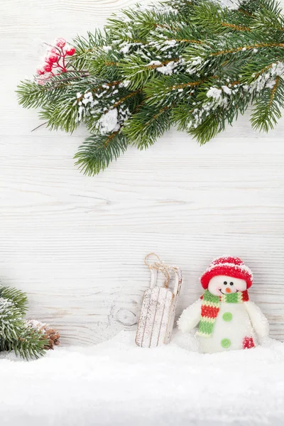 Muñeco de nieve de Navidad y juguetes de trineo y rama de abeto —  Fotos de Stock