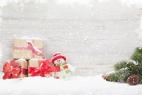 Noel hediye kutuları, kardan adam oyuncağı ve köknar ağacı dalı