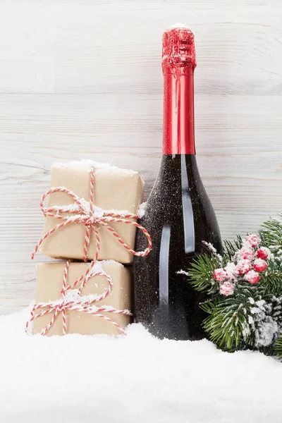 Christmas gift boxes and champagne bottle — Stock Photo, Image