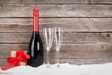 İçinde şampanya ve hediye kutusu olan bir Noel kartı.