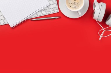 Kulaklık, malzeme ve bilgisayarı olan kırmızı ofis işyeri