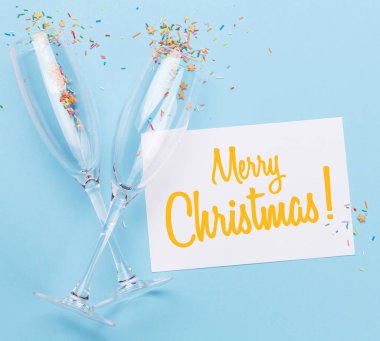 Şampanya kadehleri ve noel kartı.