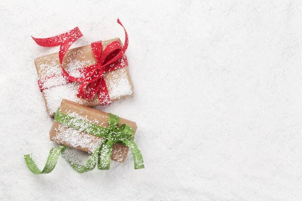 Tarjeta de felicitación navideña con cajas de regalo en nieve —  Fotos de Stock