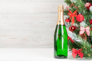 Noel kartı ile süslenmiş köknar ağacı ve şampanya