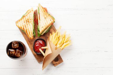 Kulüp sandviç, patates cipsi ve buzlu bir bardak kola. Fast food servisi. Kopyalama alanı olan üst görünüm