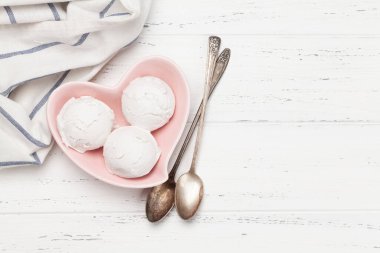 Vanilyalı dondurma kepçeleri ahşap arka planda kalp şeklinde kâsede. Kopyalama alanı olan üst görünüm. Düz yatıyordu