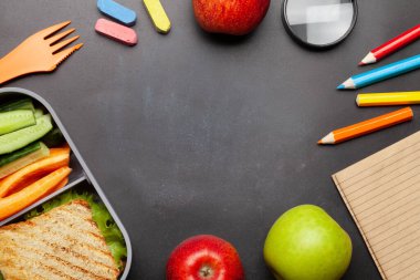 Okul beslenme çantası ve eğitim kağıtları taş masanın üzerinde. Kopyalama alanı olan üst görünüm. Düz yatıyordu