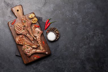 Kesme tahtasında ızgara kuzu kaburgası. Baharatlı ve baharatlı kuzu pirzolası. En üstteki tablo üzerinde kopya alanı ile birlikte görünüm