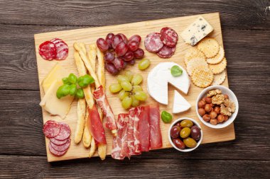 Peynir, et, üzüm ve zeytinli antipasto. Aperatif seçme tahtası. Üst Manzara. Düz yatıyordu