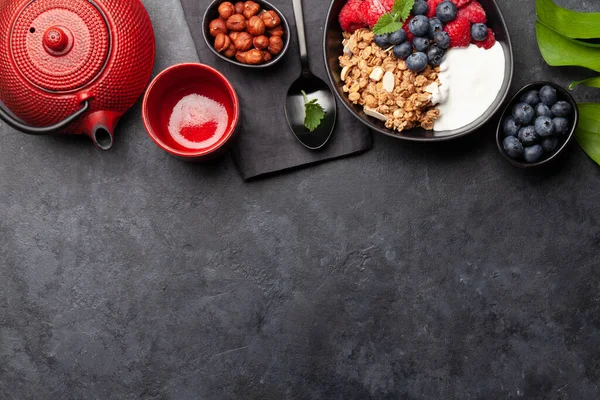 石の背景にヨーグルトと新鮮なベリーと自家製グラノーラと健康的な朝食 コピースペース付きのトップビュー — ストック写真