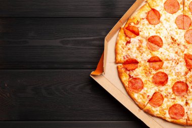 Kutusunda salam olan lezzetli biberli pizza. Kopyalama alanı olan üst görünüm. Düz yatıyordu