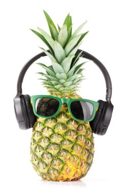 Beyaz arka planda izole edilmiş güneş gözlüklü ve kulaklıklı olgun ananas. Seyahat ve tatil kavramı
