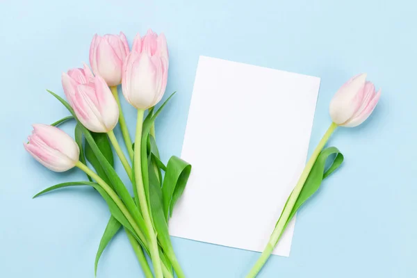 粉红色的郁金香花在蓝色的背景上 带有复制空间的贺卡模板 — 图库照片