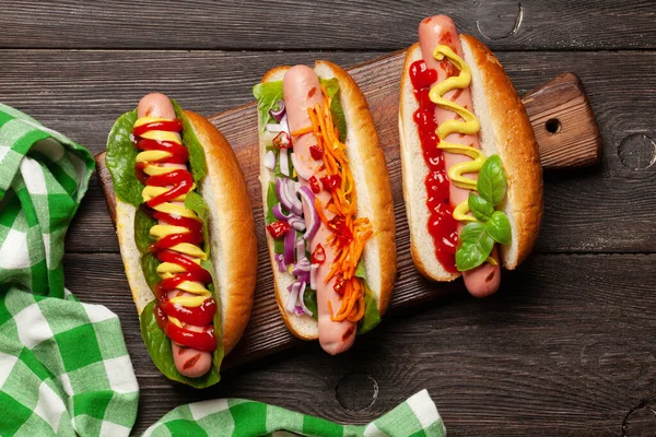 Verschiedene Würstchen Mit Gemüse Salat Und Gewürzen Auf Holzboden Ansicht — Stockfoto