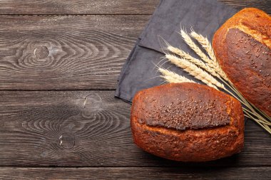 Tahta masadaki tohumlu ev yapımı organik ekmek. Üst görünüm düzlüğü kopyalama alanı ile yatıyordu