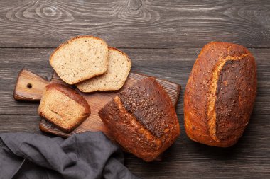 Tahta masadaki tohumlu ev yapımı organik ekmek. Üst görünüm düzlüğü kopyalama alanı ile yatıyordu