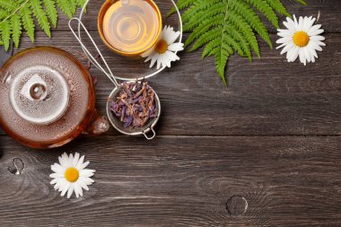 Çaydanlıkta bitki çayı ve tahta masada fincan. Kopyalama alanı olan üst görünüm. Düz yatıyordu