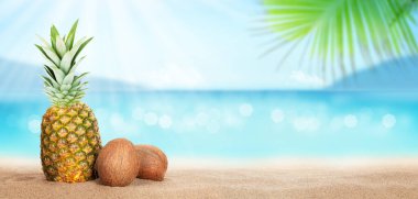 Yaz tropikal denizi, köpüklü dalgalar, ananas ve hindistan cevizleri sıcak kumsalda. Kopya alanı ile seyahat ve tatil kavramı