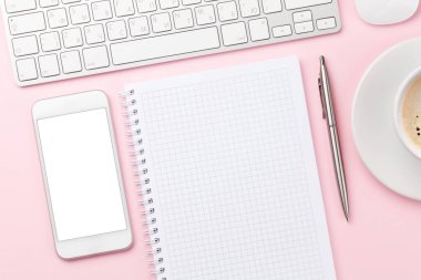 Bilgisayarlı, akıllı telefonlu, malzemeli ve kahveli pembe çalışma masası. Metnin ya da uygulaman için en üstteki görünüm. Düz yatıyordu