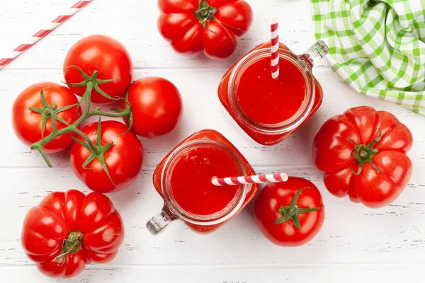 新鮮なトマトジュースと熟したトマトを木製のテーブルに置きます トップ表示 — ストック写真