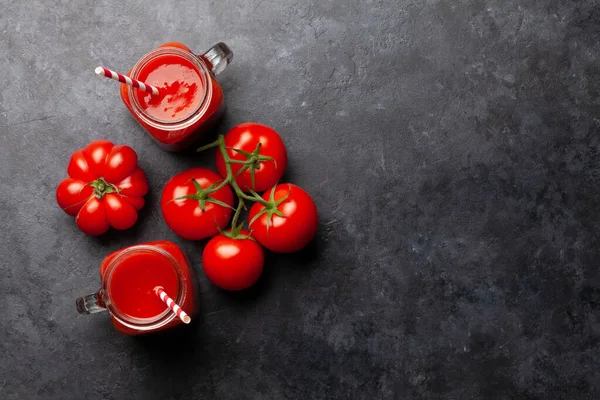 石のテーブルの上に新鮮なトマトジュースと熟したトマト コピースペース付きのトップビュー — ストック写真