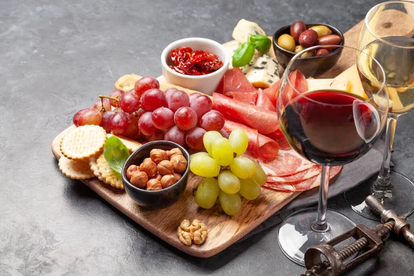 葡萄和橄榄木木板和红 白酒杯上的开胃菜选择 — 图库照片