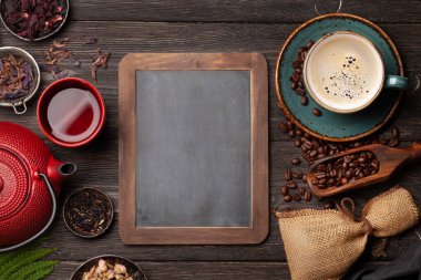 Tahta masada çeşitli bitki çayları ve espresso kahveleri var. Kopya alanı için yazı tahtası olan üst görünüm. Düz yatıyordu