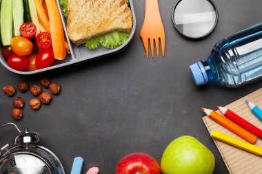 Okul beslenme çantası ve eğitim kağıtları taş masanın üzerinde. Kopyalama alanı olan üst görünüm. Düz yatıyordu