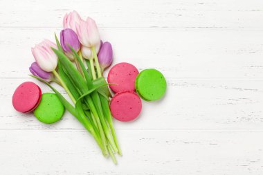 Lale çiçekleri ve ahşap arka planda kurabiyeler. Kopya alanı olan tebrik kartı şablonu