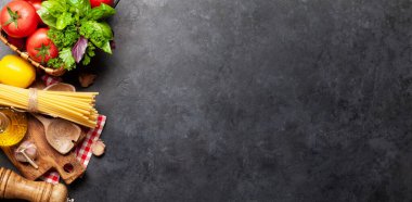 İtalyan mutfağı malzemeleri. Bahçe domatesleri, makarna, otlar ve baharatlar. Kopyalama alanı olan üst görünüm. Düz yatıyordu