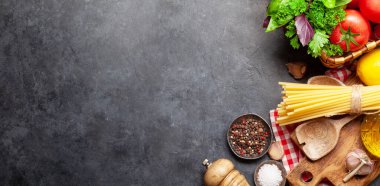 İtalyan mutfağı malzemeleri. Bahçe domatesleri, makarna, otlar ve baharatlar. Kopyalama alanı olan üst görünüm. Düz yatıyordu