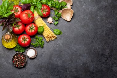 İtalyan mutfağı malzemeleri. Bahçe domatesleri, makarna, otlar ve baharatlar. Kopyalama alanı olan üst görünüm. Düz yatıyordu