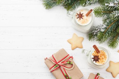 Eggnog. Geleneksel Noel kokteyli, Noel hediyesi kutuları ve ahşap masada zencefilli kurabiye. En üstteki düz yerde. Selamlarınız için yer var.