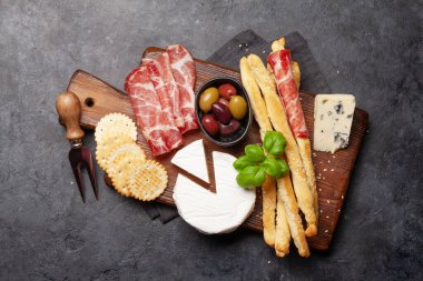Peynir, et ve zeytinli antipasto. Aperatif seçme tahtası. Üst Manzara. Düz yatıyordu