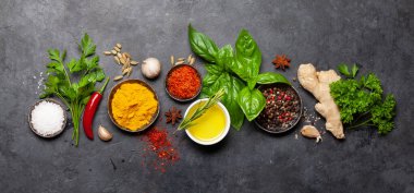 Koyu taş masadaki çeşitli baharatlar, otlar ve baharatlar. Hint mutfağı. Üst görünüm düzlüğü