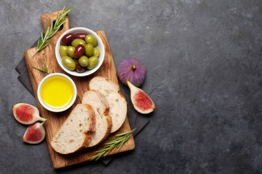 Olgun zeytin, zeytin yağı, incir ve ciabatta ekmeği. Üst görünüm düzlüğü kopyalama alanı ile yatıyordu