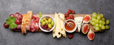 Prosciutto, peynir, incir ve üzümlü Antipasto tabağı. Aperatif kurulu. Üst görünüm düzlüğü