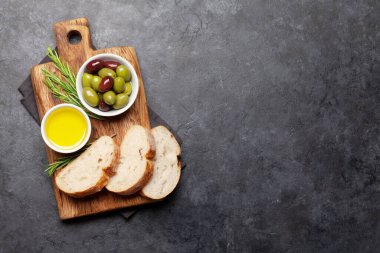 Olgun zeytin, zeytinyağı ve ciabatta ekmeği. Üst görünüm düzlüğü kopyalama alanı ile yatıyordu