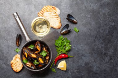 Şarap soslu ve baget ekmekli geleneksel deniz ürünleri midyesi. Üst görünüm düzlüğü kopyalama alanı ile yatıyordu