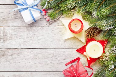 Noel tebrik kartı, köknar ağacı, hediye kutusu ve ahşap arka planda mumlar. En üstteki görünüm düzlüğü Xmas selamlamalarınız için kopyalama alanı ile yatar