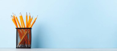 Ofis malzemeleri ve okul gereçleri mavi duvarın önünde.