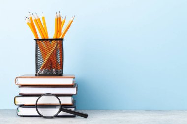 Ofis malzemeleri ve okul gereçleri mavi duvarın önünde.