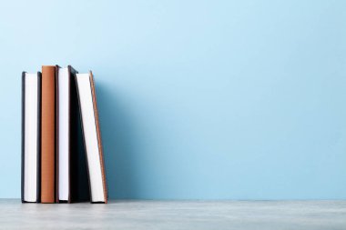 Ofis not defteri malzemeleri ve okul kitapları mavi duvarın önünde metnin için fotokopi alanı ile birlikte.