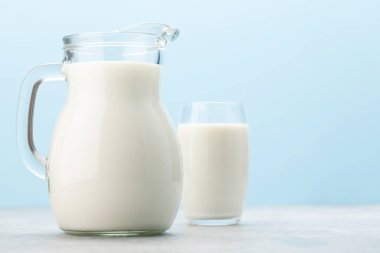 Süt cam ve sürahi mavi arkaplan önünde kopyalama alanı ile