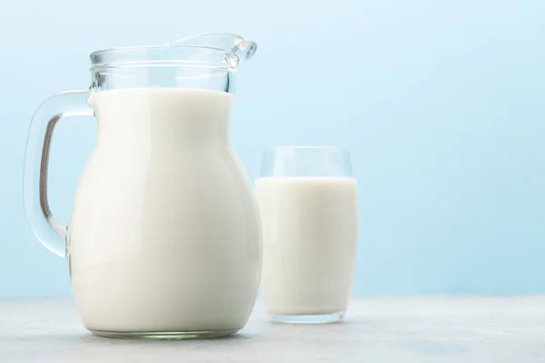 Mjölk Glas Och Kanna Framför Blå Bakgrund Med Kopieringsutrymme — Stockfoto