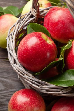 Tahta masadaki sepetin içinde olgun meyve bahçeleri.